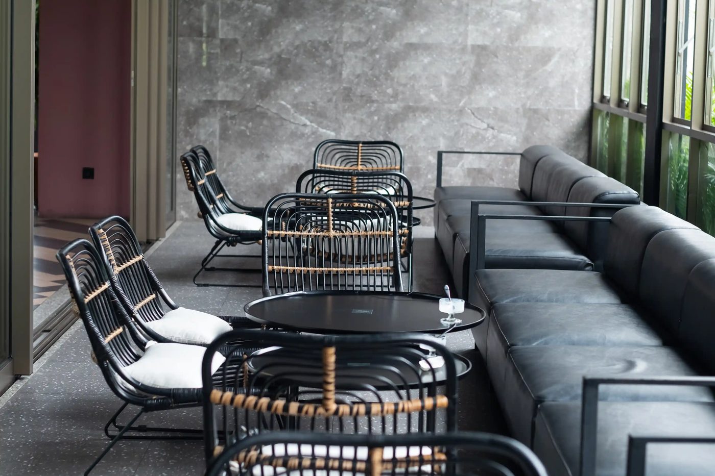 Lounge-Terrasse mit Rattan-Sesseln und Leder-Sofas — eingerichtet von Wirt & Werk Gastromöbel